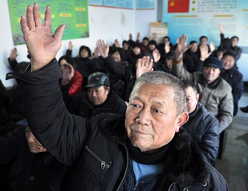 这是2014年1月5日,在山东省滨州市邹平县临池镇望京村,村民代表崔孝贵在每月一次的“民主议政日”活动现场就旧村改造问题向村委会成员举手提问。2014年中央一号文件指出,深入推进村务公开、政务公开和党务公开,实现村民自治制度化和规范化。