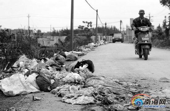 海口仲恺村委会,垃圾堆成山村民出行受影响。