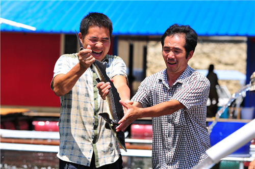 8月7日,长顺县敦操乡黄花寨水库,网箱养鱼户韦小八、韦小全兄弟俩正忙着捕捞鲟鱼。