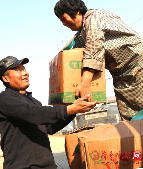 种菜社员程仁德夫妇将蔬菜按标准直接采摘、过磅、包装,装上超市车辆。