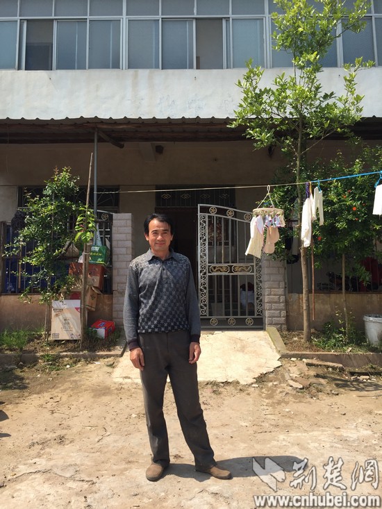 站在在自家楼房前的张家良