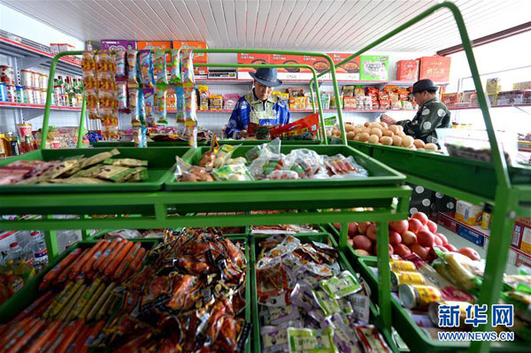 米·巴特尔(左)在嘎查的小超市选购日用品(11月13日摄)。