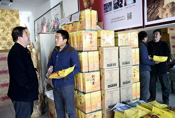 12月3日,“沁州黄小米网店”的店主桂宝强(右)在考察货源。