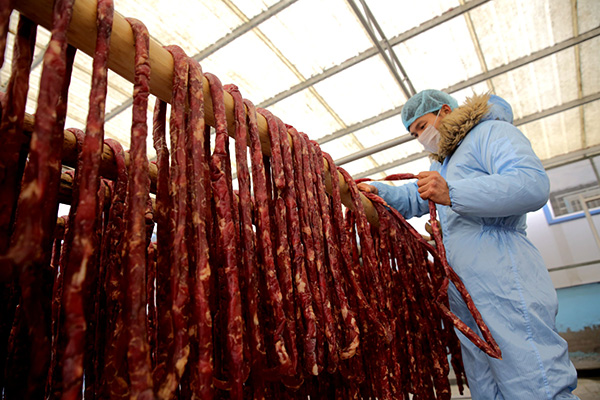 12月19日,江苏睢宁县一食品加工厂工人在晾晒香肠。