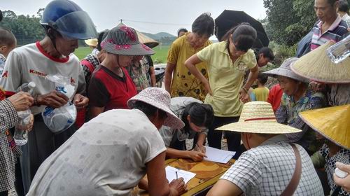 图为当地农民在签领农药物资。