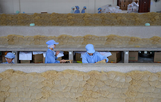 6月18日,工人在江西会昌五丰食品有限公司包装米粉。