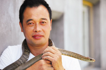 王孝林将一条蛇挂在脖子上,感受它带来的冰凉快感