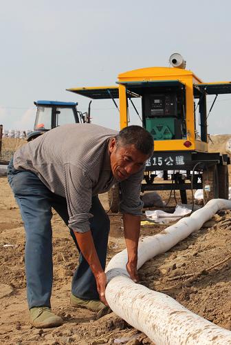 9月10日,在黑龙江省同江市三村镇二村村,村民刘志江查看抽水设备运行情况