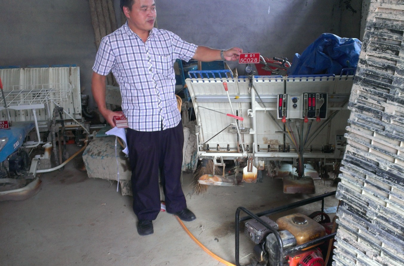 工作人员正给一台手扶步进式插秧机进行上牌