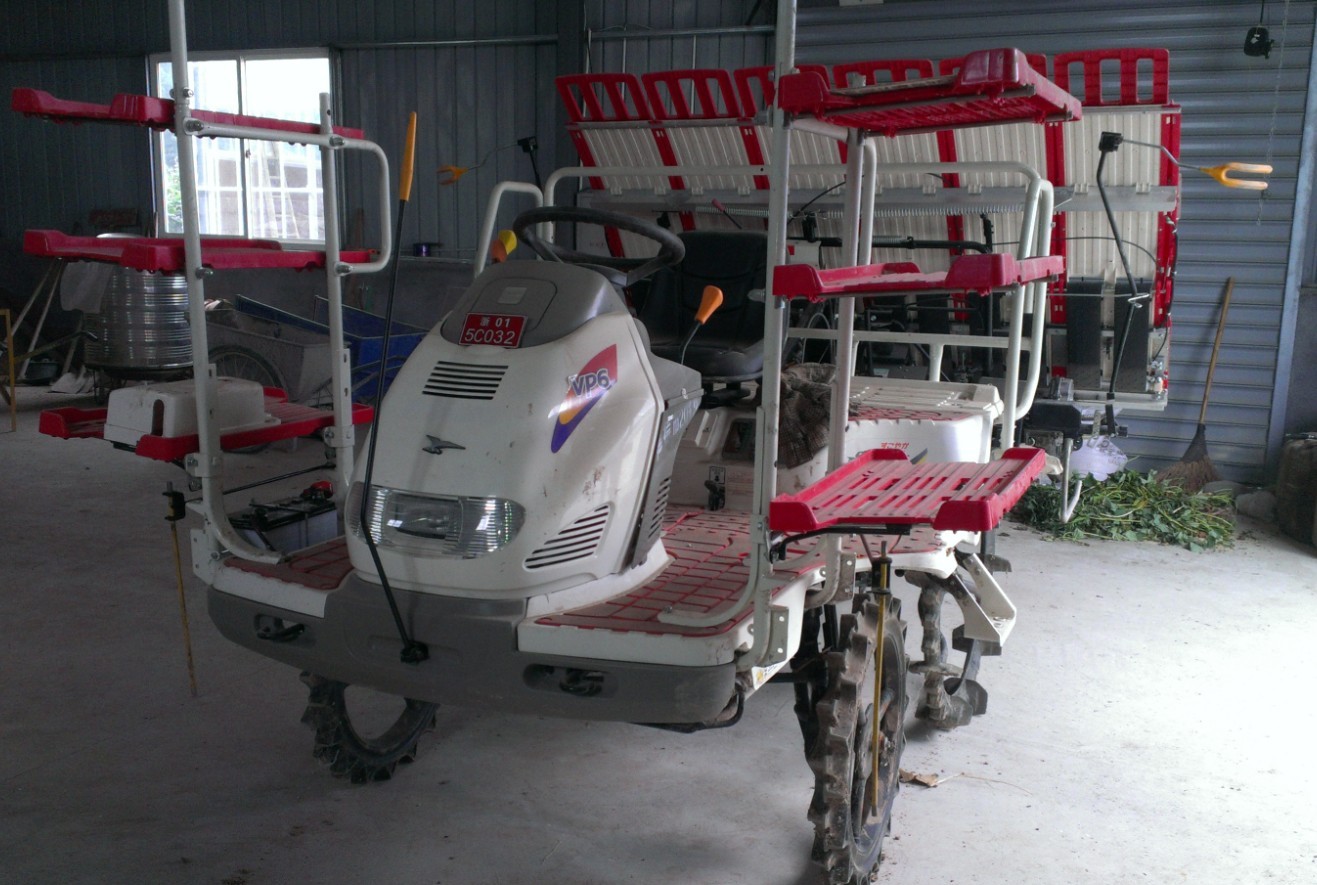 停在仓库中的上好牌照的乘坐式插秧机