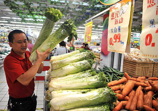 10月10日,超市工作人员将大白菜上架,保证“一元菜”货源充足