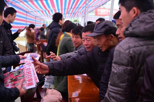 3月1日,在高安县农技农机下乡服务现场,参观者们争相索取赠送的农业知识宣传册。