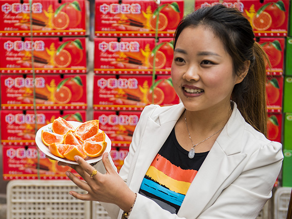 3月25日,湖北省秭归县县城一名脐橙销售商在展示切开的“红肉脐橙”。