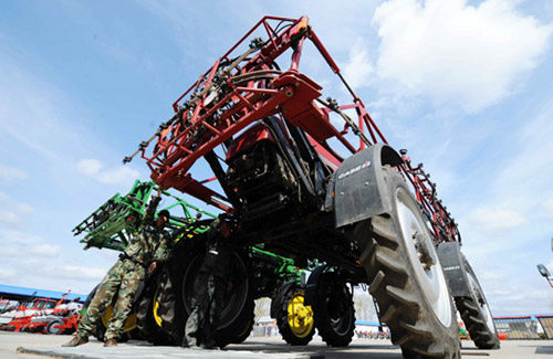 5月10日,在克山县仁发现代农业农机专业合作社的大院里,社员李德臣(左)和李广德在维修喷农药的大型农机 5月10日,在克山县仁发现代农业农机专业合作社的大院里,社员李德臣(左)和李广德在维修喷农药的大型农机